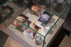 Patricia L. Boyd. Problem of containment, 2025 (detail). Moving box, plywood vitrine, prints, jars, drinking glasses, paint. 91 x 87 x 87 cm. Christian Andersen